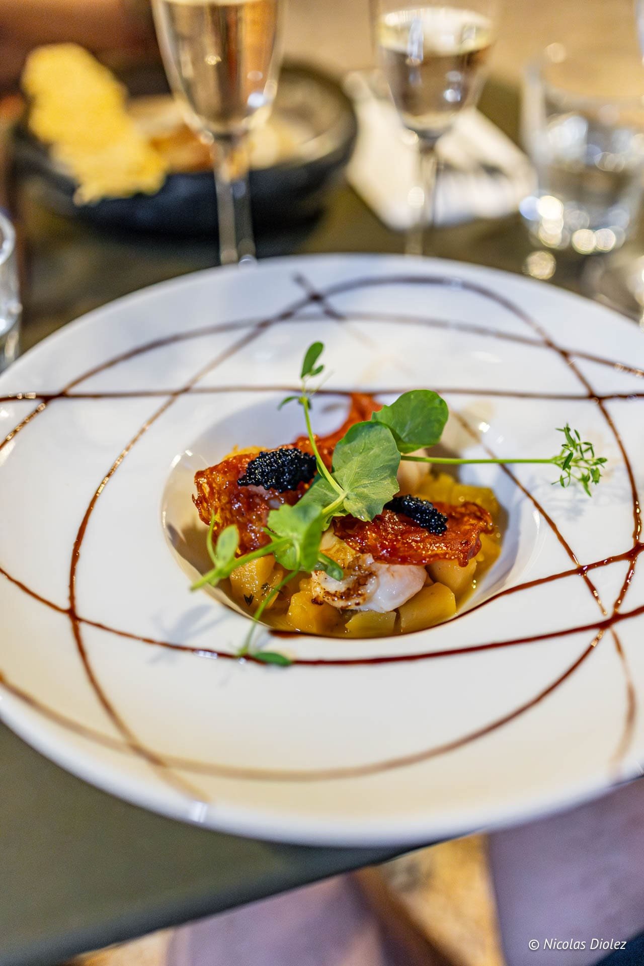 Restaurantterrasse mit Gästen unter Sonnenschirmen und sanfter Beleuchtung in der Nähe von Cahors.