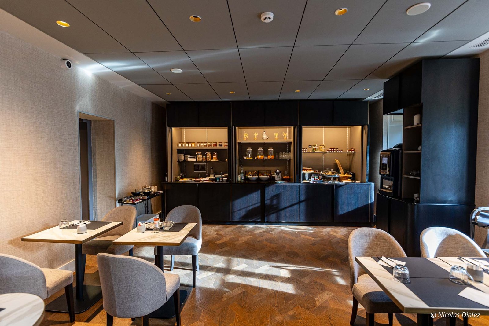 Moderne ontbijtzaal met buffet en gedekte tafels, warme sfeer.