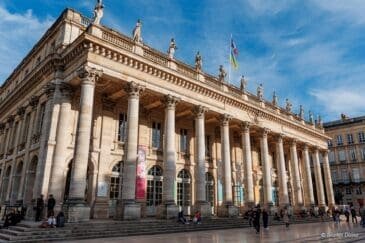 Grand Théâtre de Bordeaux avec colonnade, statues et drapeaux français et ukrainien.