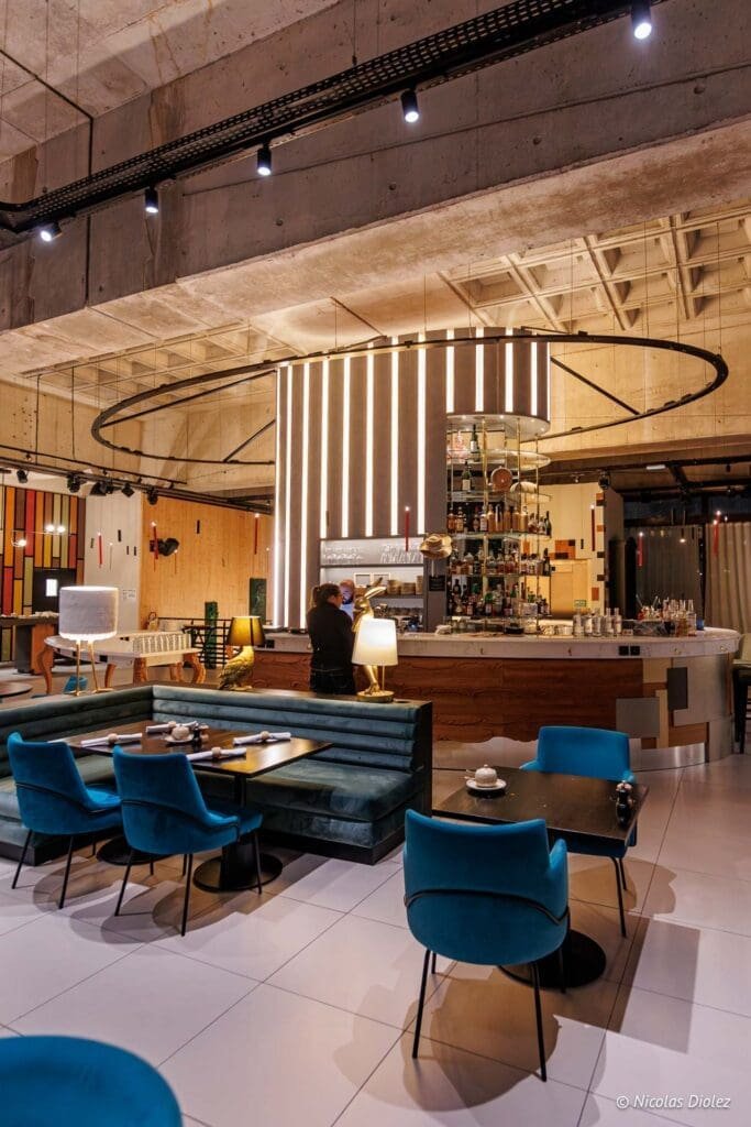 Modern interieur restaurant Bordeaux met fluwelen banken en verlichte bar.