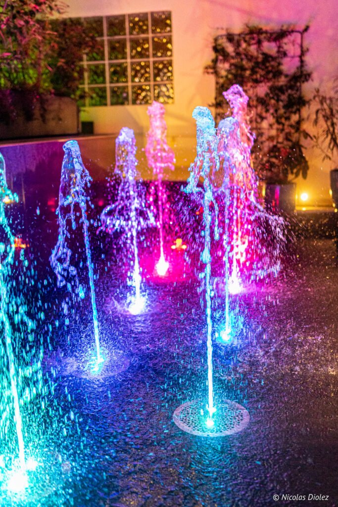 Getti d'acqua illuminati multicolori della fontana nella veranda del ristorante dell'hotel Paris j'Adore.