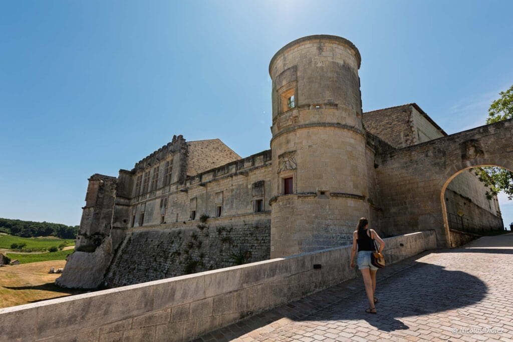 Château de Bouteville avec femme marchant vers l'arche et la tour.