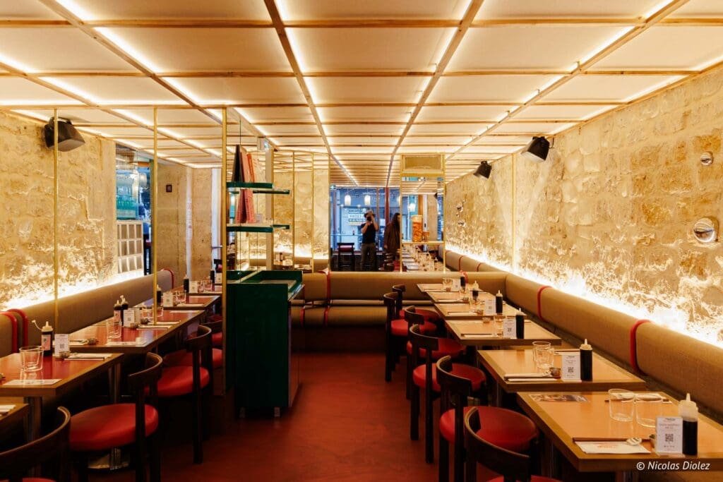 Intérieur Hallyu Kitchen Paris, tables dressées et murs en pierre.