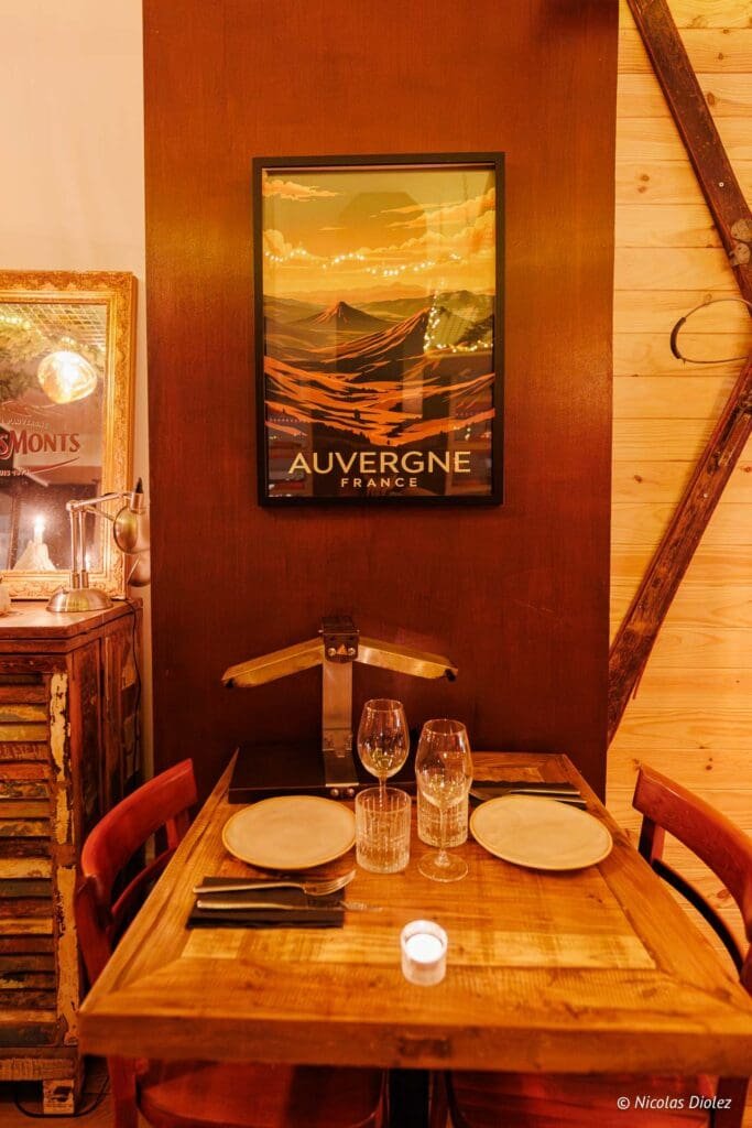 Table dressée avec affiche Auvergne France, verres et bougie.