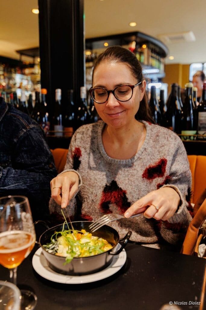 Femme mangeant un plat garni de légumes dans un restaurant de Chartres.