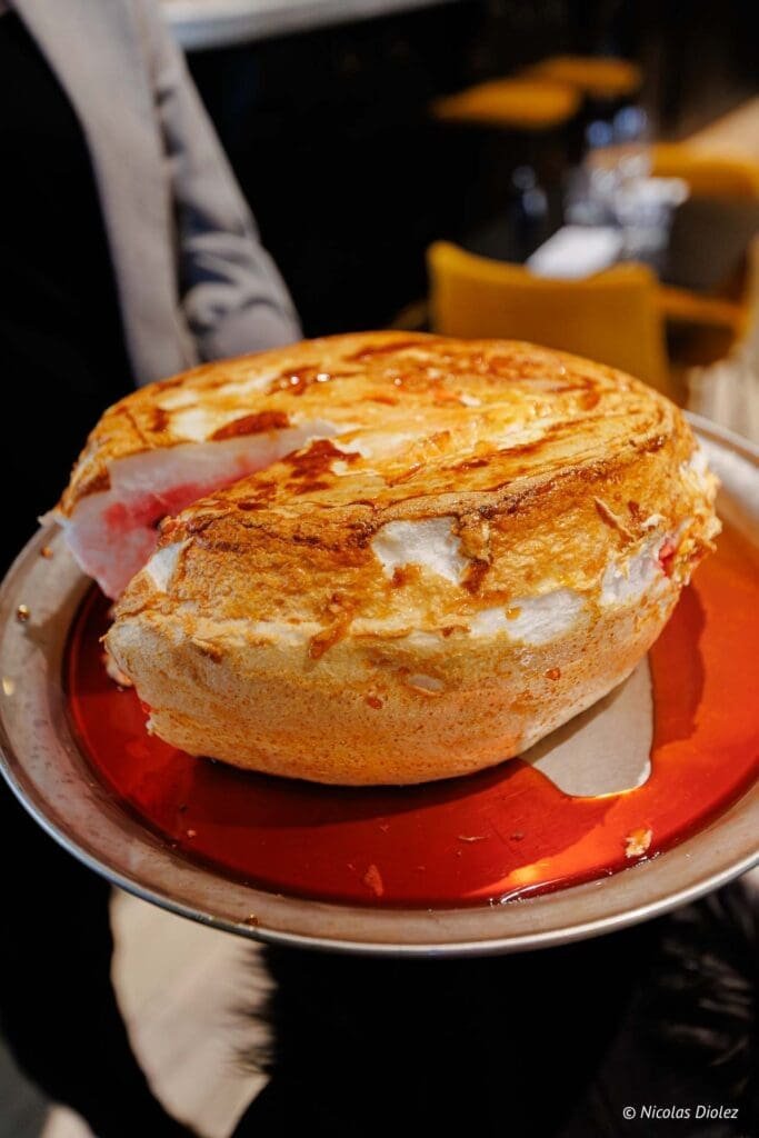 Soufflé Chartres Lumières servi sur une assiette avec un sirop rouge.