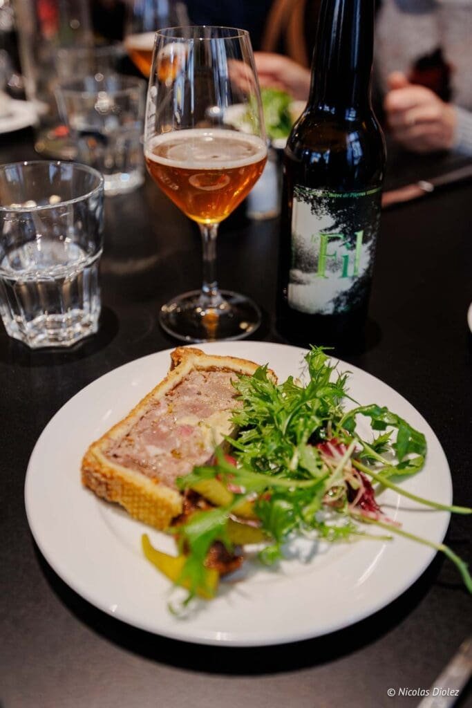 Pâté en croûte, salade, bière artisanale et verre dans un restaurant à Chartres.