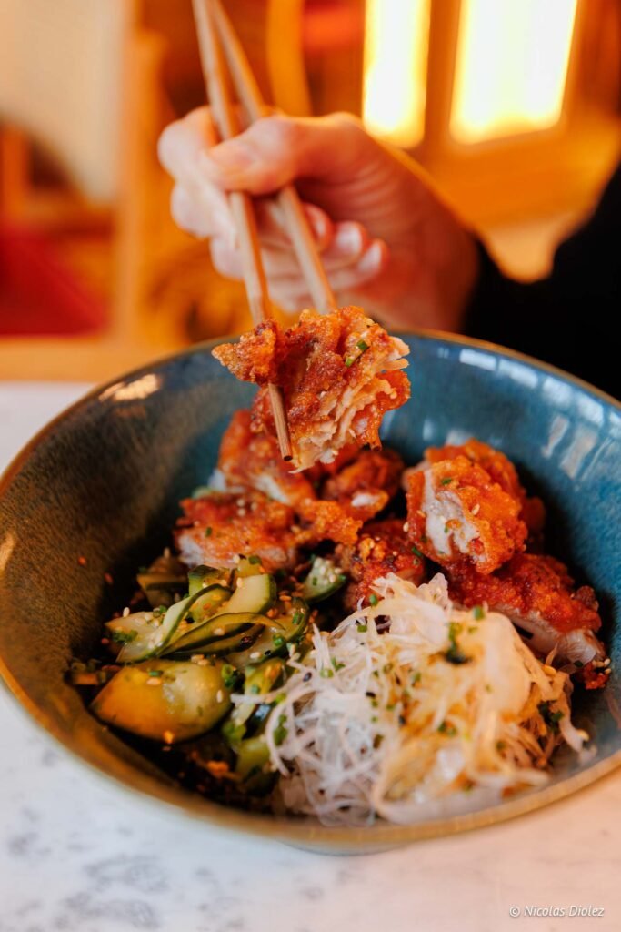 Poulet frit karaage asiatique dans un bol avec baguettes.