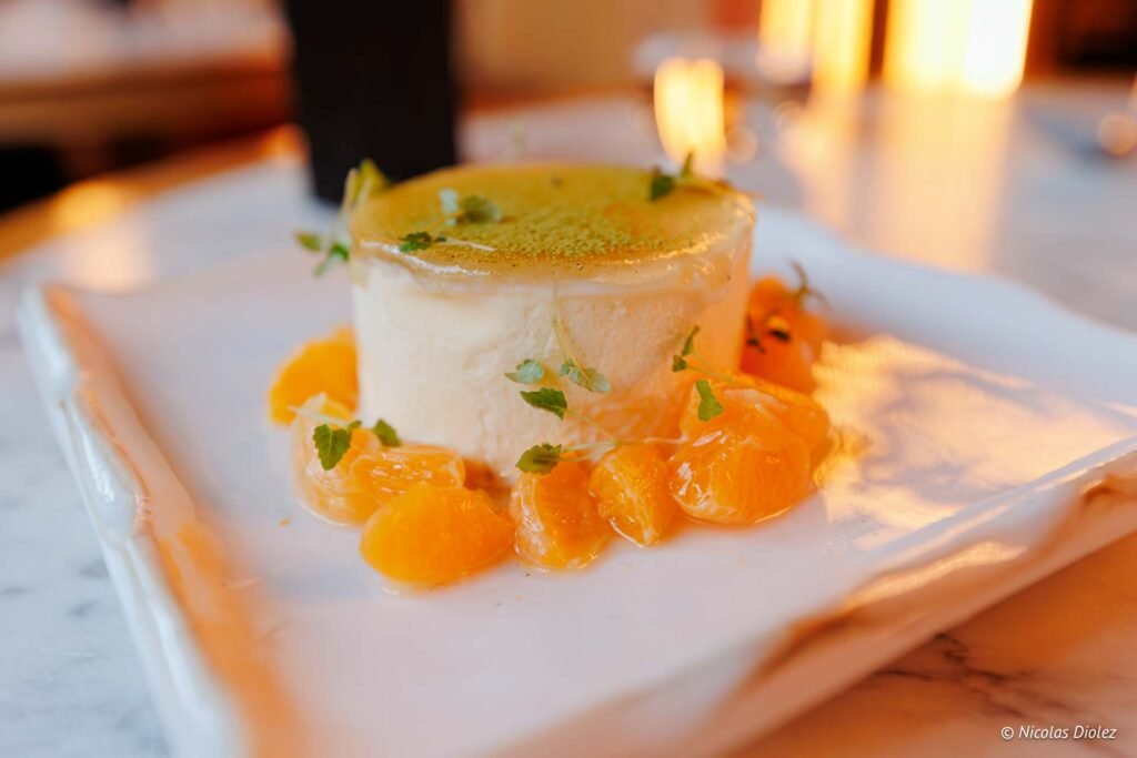 Dessert crémeux aux suprêmes de mandarine et herbes fraîches.