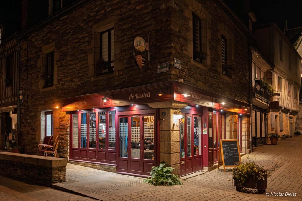 Crêperie Ar Kastell la nuit, avec panneaux Rue Beaumanoir et Rue du Château.