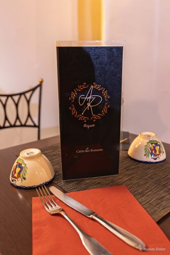 Menu Crêperie avec Carte des Boissons, couverts et bols décoratifs.