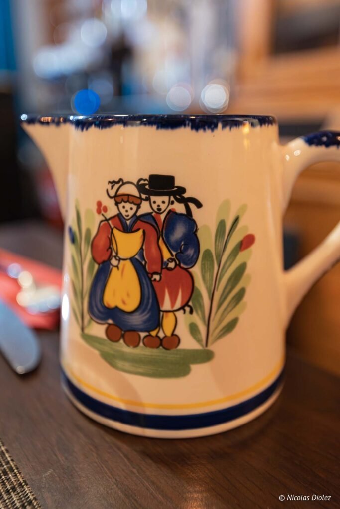 Pichet en faïence à motif couple en costume breton traditionnel.