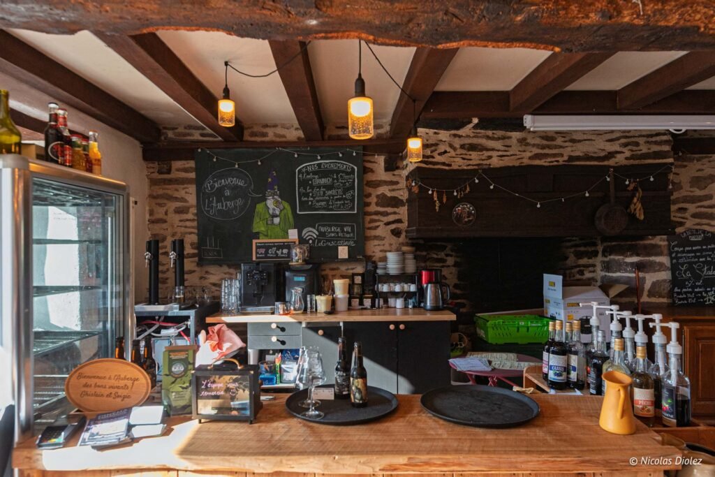 Bar de l'Auberge du Val sans Retour avec tableau noir et robinets de bière.