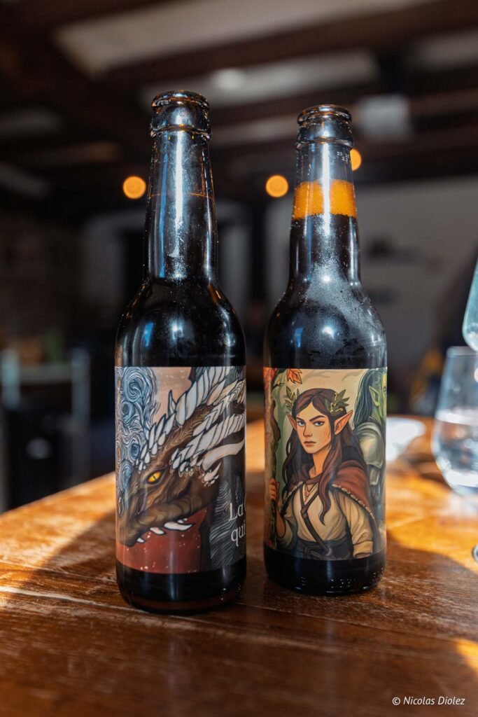 Deux bouteilles de bière artisanale avec étiquettes fantasy, dragon et elfe.