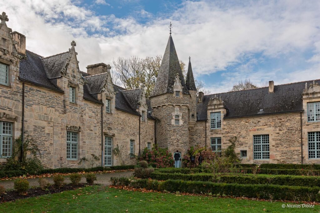 Château de Rochefort-en-Terre avec tour crénelée et jardin d'automne.