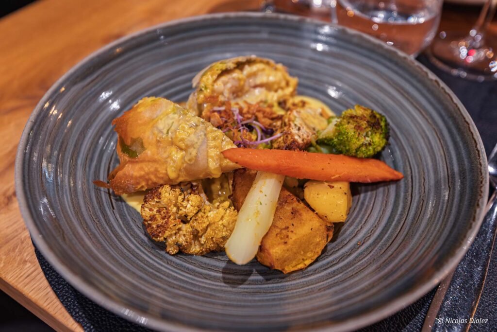 Assiette de plat gastronomique avec feuilleté et légumes rôtis chez Simon Josselin.