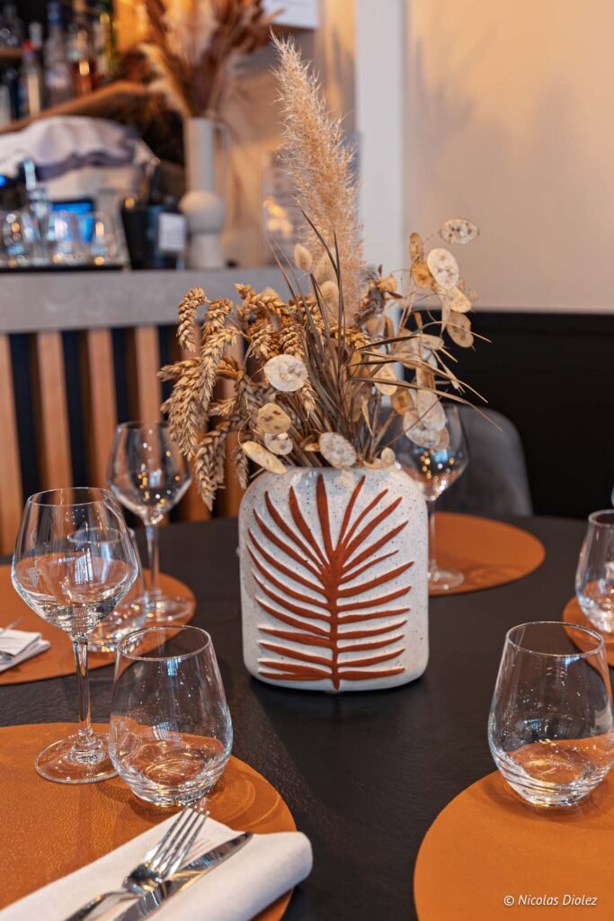 Centre de table Chez Simon Josselin: vase déco fleurs séchées et verres à vin.