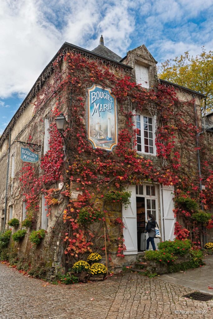 Boutique Bougies Marie à Rochefort-en-Terre, murs couverts de vigne rouge.