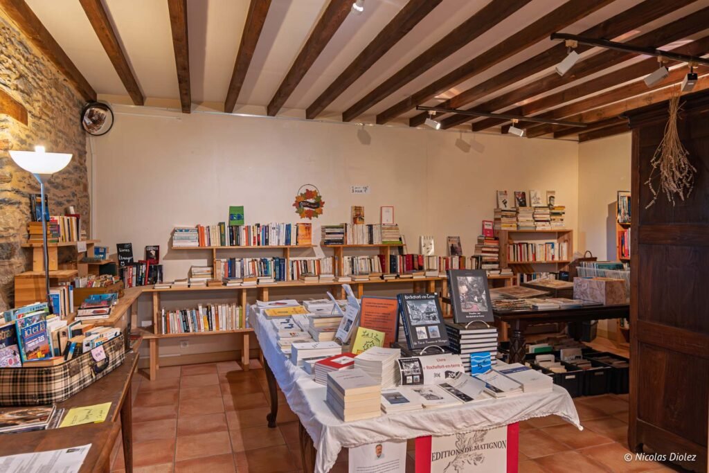 Librairie à Rochefort-en-Terre avec étagères chargées et livres en exposition.