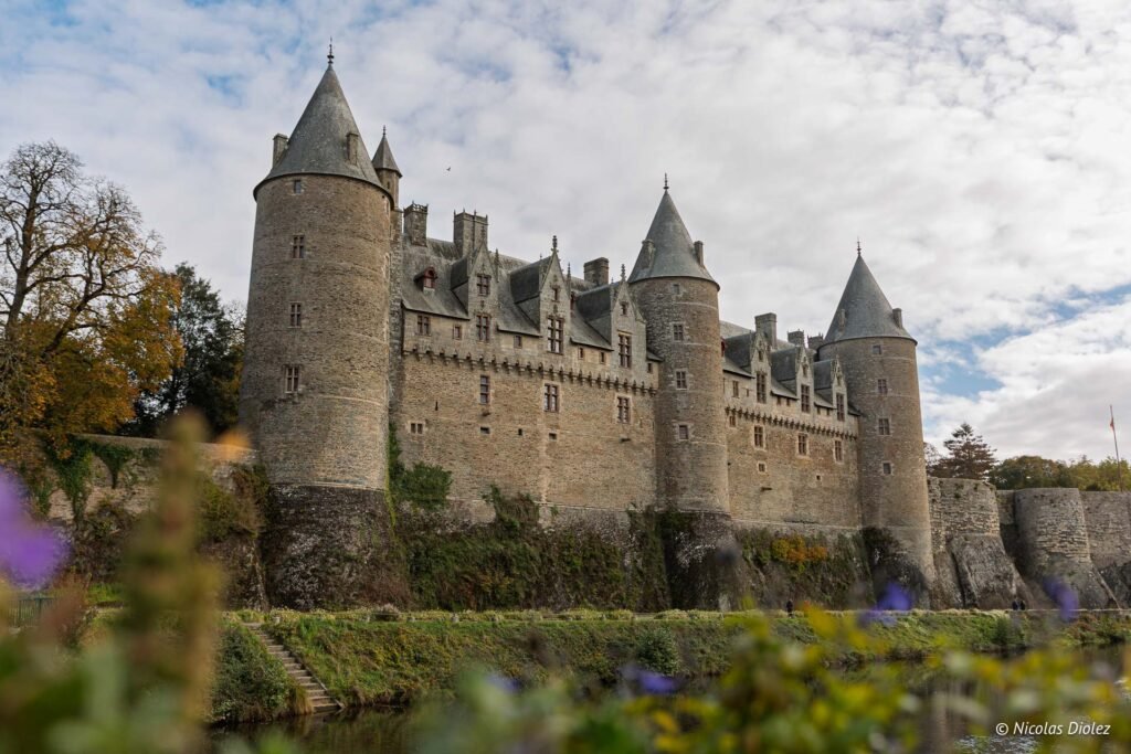 Château de Josselin dominant l'eau, murs de pierre et toits en ardoise.