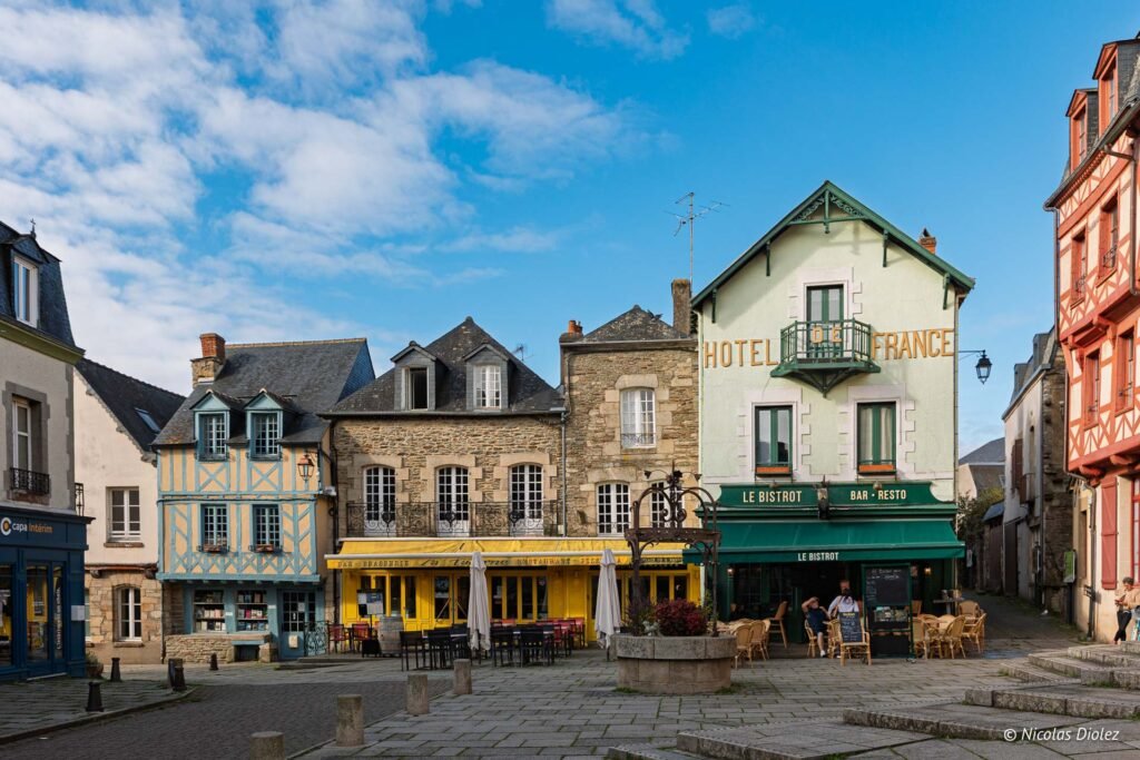 Place publique Josselin avec maisons à colombages et Hôtel de France.