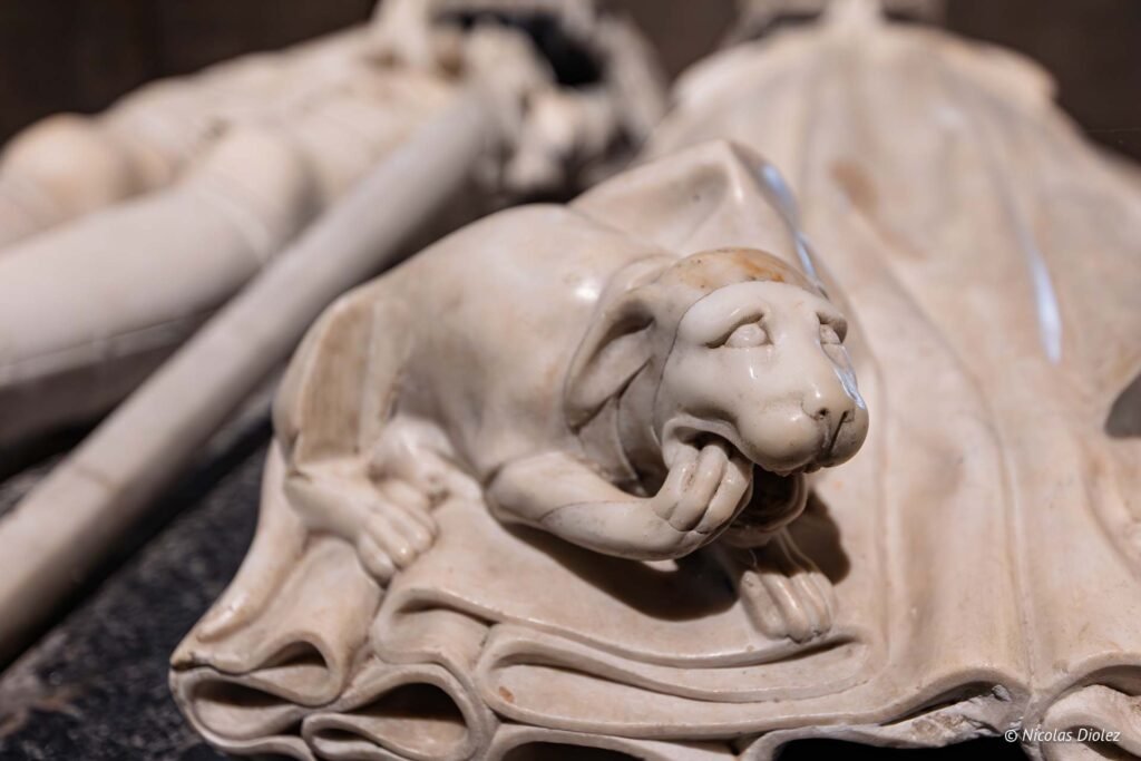 Sculpture en marbre d'un lion léchant sa patte sur un tombeau, Josselin.