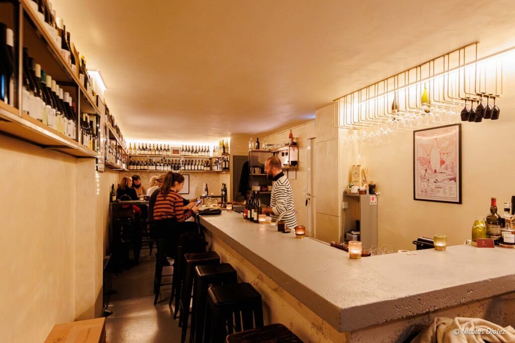 Bar à vins La Cave Tire-Bouchon avec clients et serveur.