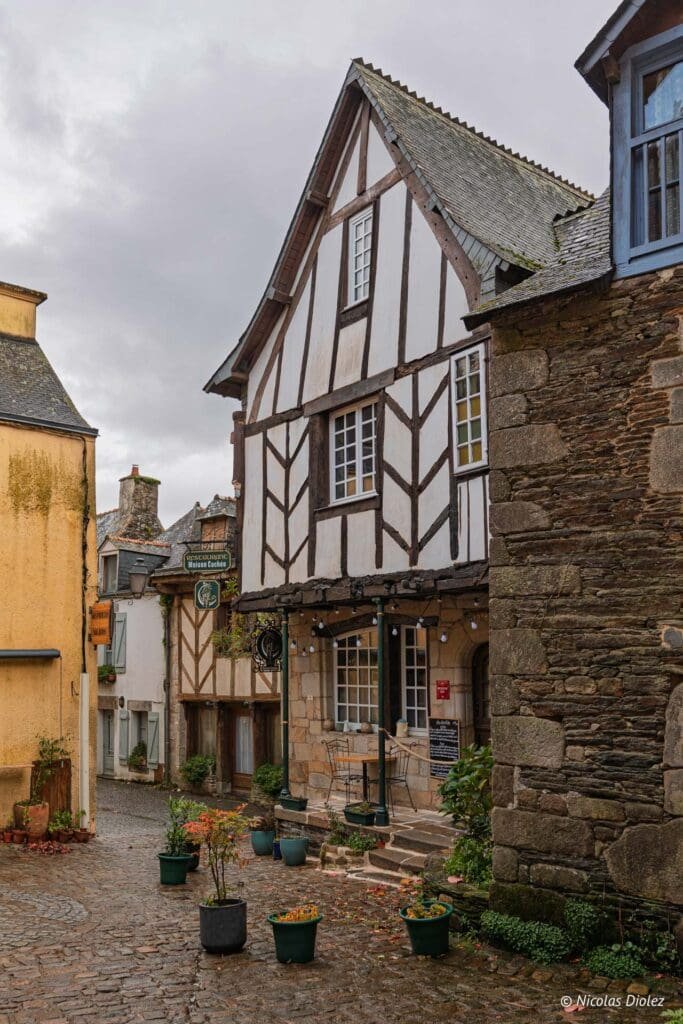 Restaurant La Maison Cachée colombages et pavés dans une rue ancienne.