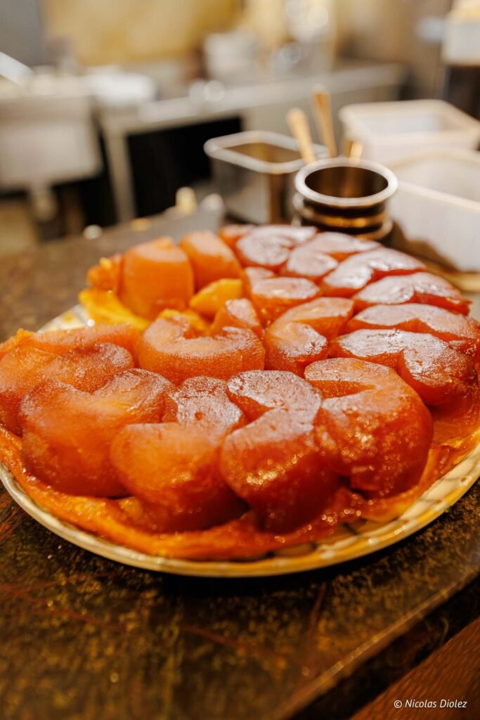 Tarte Tatin aux pommes caramélisées sur plat, cuisine professionnelle.
