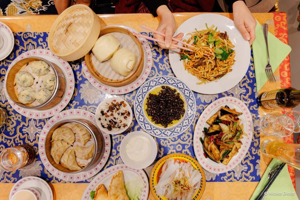 Repas tibétain avec momos, nouilles, pain vapeur et plats variés.