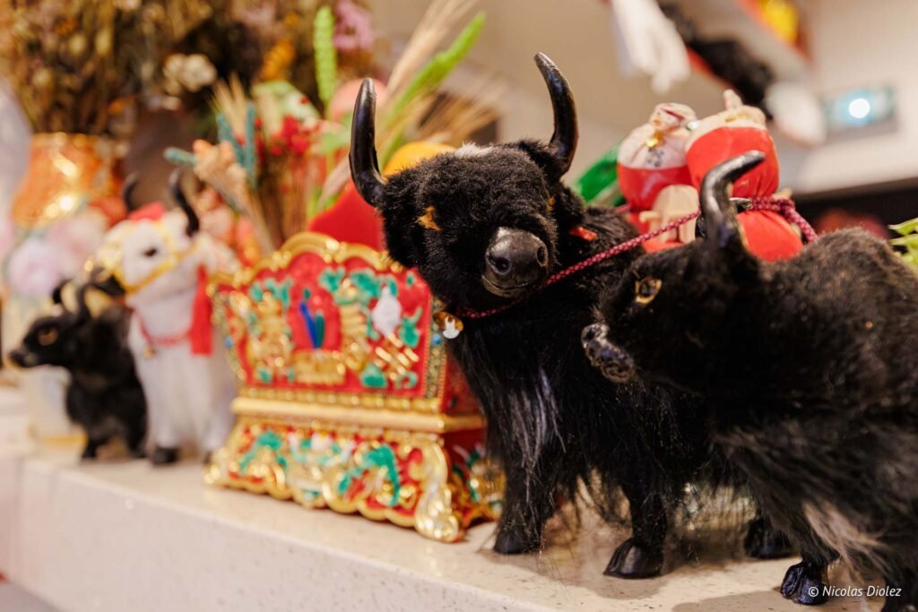 Figurines de yaks noirs et blancs près d'un objet décoratif tibétain.
