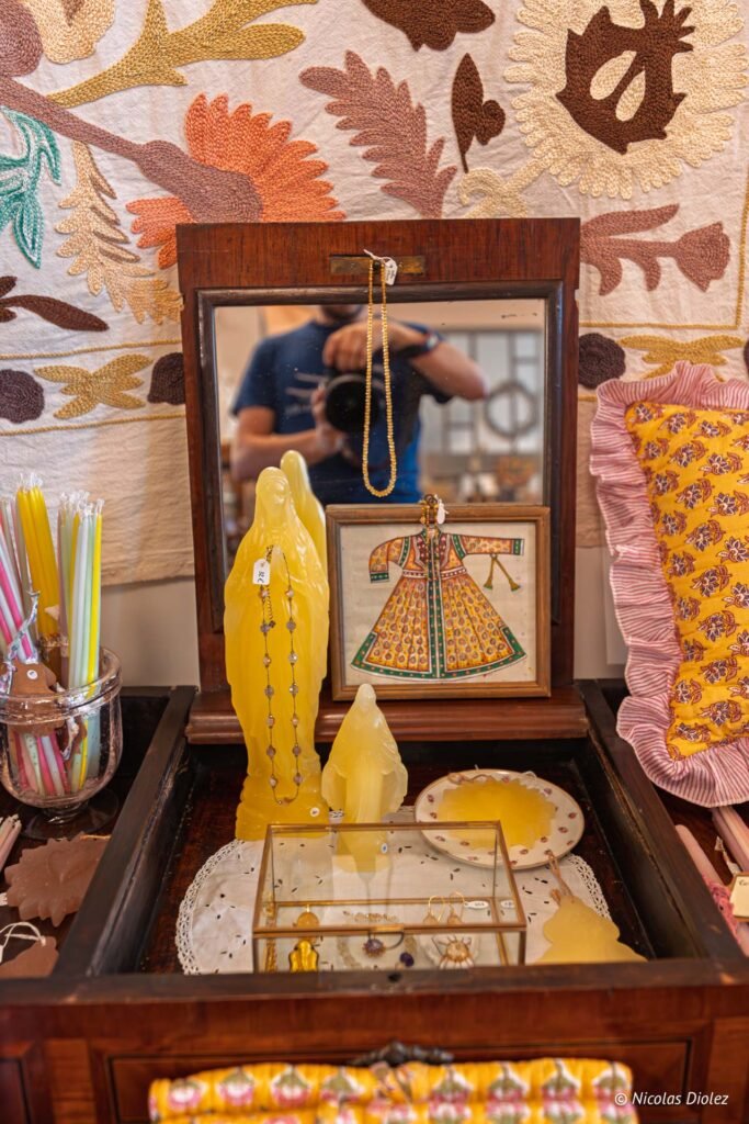 Vente d'objets artisanaux: statues de cire, bijoux, miroir et textiles brodés.
