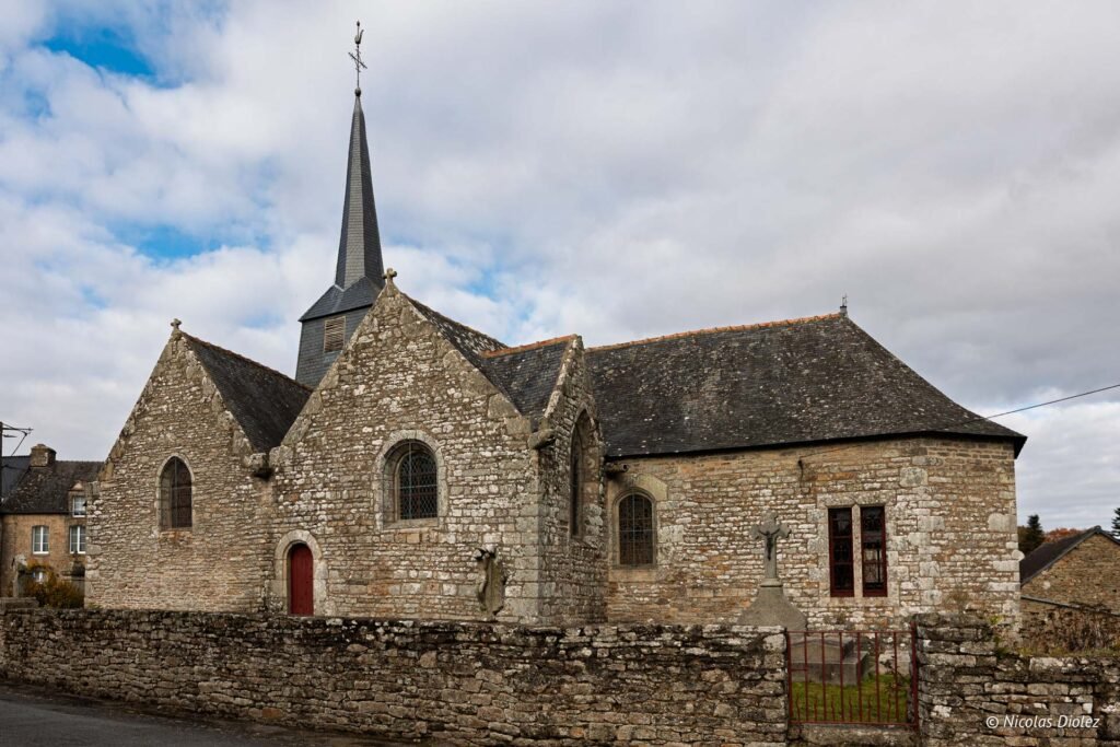 Église en pierre avec clocher en ardoise et mur d'enceinte à Maison-Ogigi.