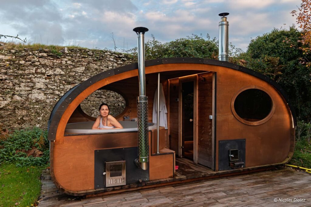 Femme dans un jacuzzi extérieur chauffé au bois près du Manoir du Vau d'Arz.