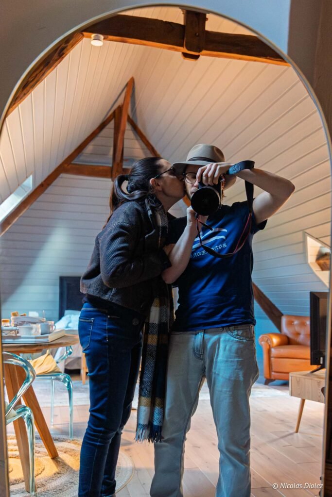Couple faisant un selfie au miroir sous un toit mansardé au Manoir du Vau d'Arz.