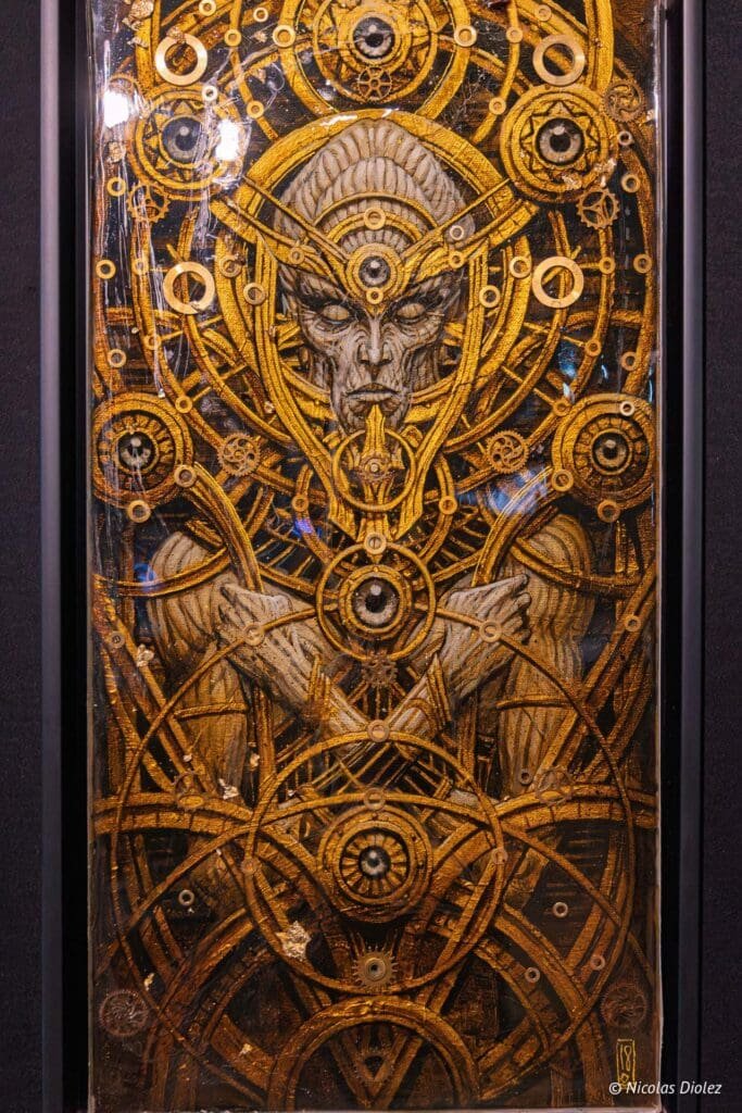 Visage mystique doré entouré d'engrenages et de cercles. Art Nicolas Diolez.