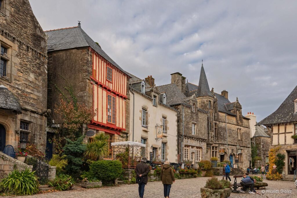 Ruelles pavées de Rochefort-en-Terre avec maisons à colombages et tourelle en pierre.