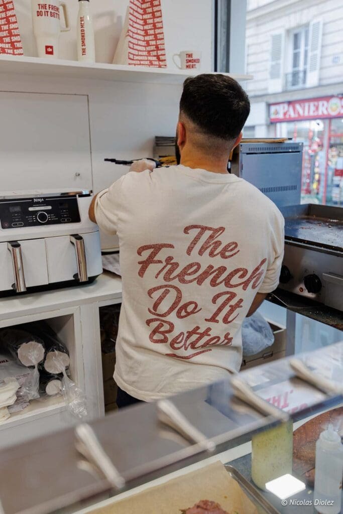 Cuisinier portant un t-shirt "The French Do It Better" devant une friteuse Ninja.