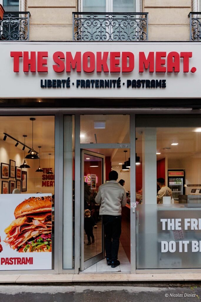 Façade du restaurant "The Smoked Meat" affichant "Liberté • Fraternité • Pastrame".