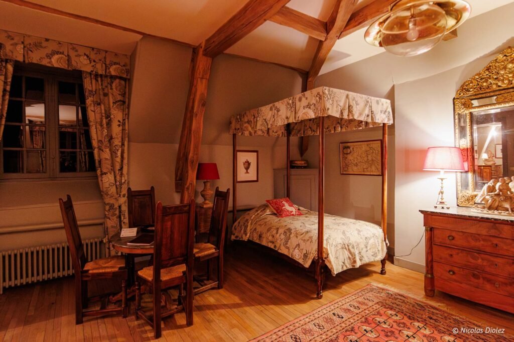 Chambre d'hôtes rustique au Château de la Rivière avec lit à baldaquin.