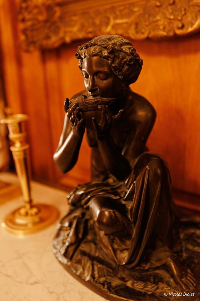 Sculpture en bronze d'une femme nue soufflant dans une conque au Château de la Rivière.