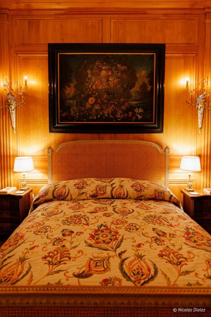 Chambre d'hôtes luxueuse au Château de la Rivière, boiseries et tableau fleuri.