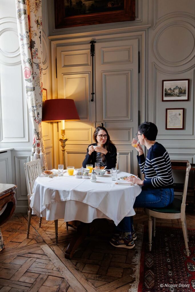 Couple prenant le petit-déjeuner dans un salon élégant du Château de la Rivière.