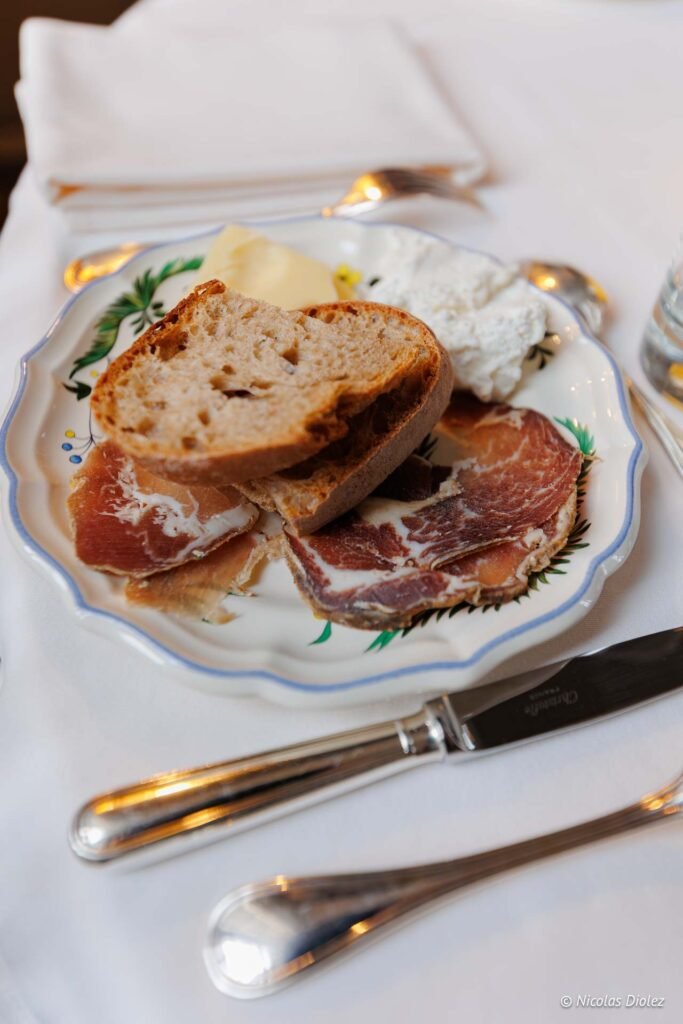 Assiette de brunch avec pain, charcuterie, fromage blanc et beurre au Château de la Rivière.