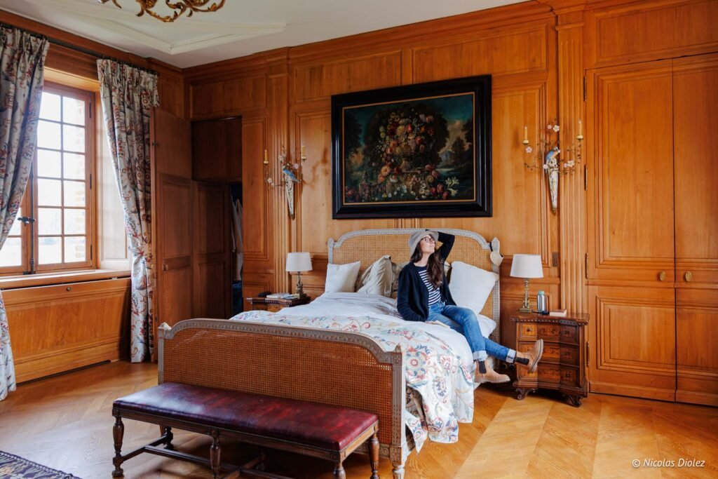 Femme se relaxant dans une chambre d'hôtes luxueuse au Château de la Rivière.