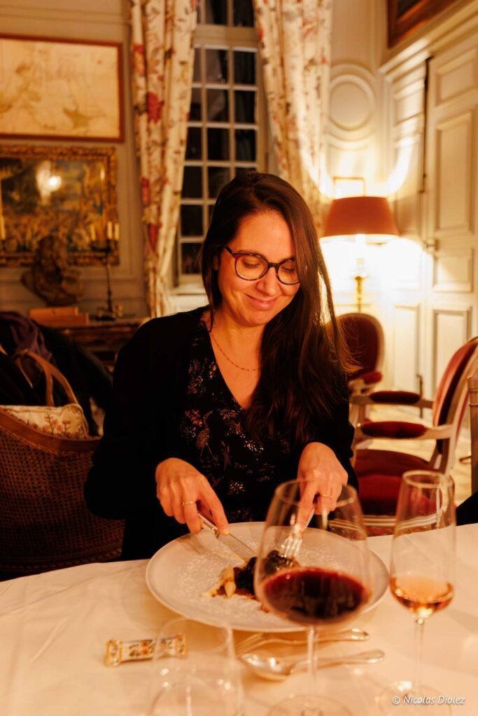 Dîner gastronomique : femme dégustant un dessert avec du vin au Château de la Rivière.
