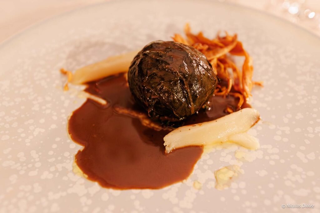 Plat gastronomique servi avec sauce brune et légumes au Château de la Rivière.