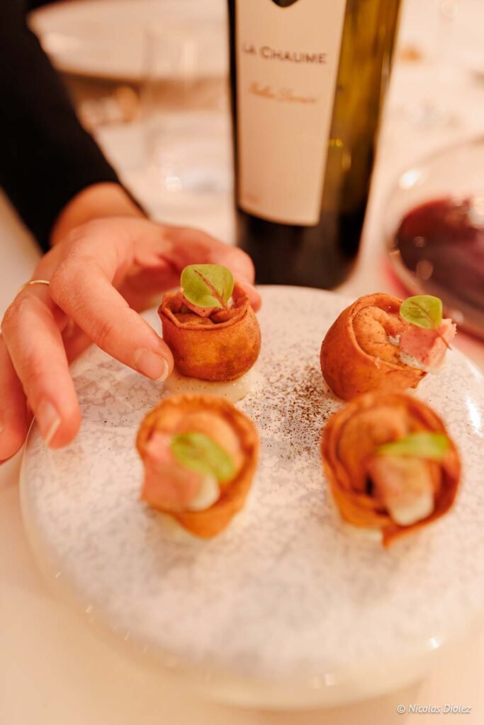Mise en bouche gastronomique et bouteille de vin La Chaume lors d'un dîner au Château.