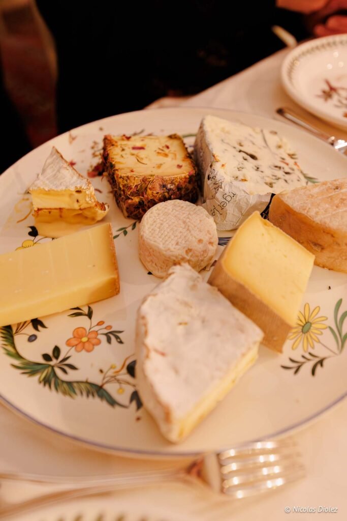 Assortiment de fromages variés servi sur assiette décorée au Château de la Rivière.
