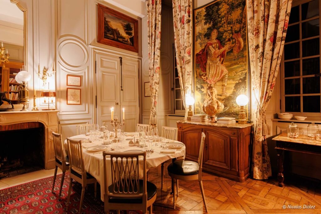 Salle à manger élégante du Château de la Rivière avec table dressée pour dîner.